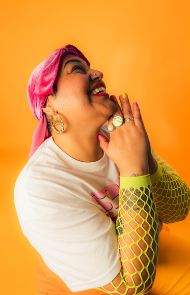 Levia the waxer with her hands tucked cute by her face with a big smile. 